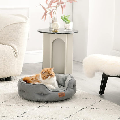 The British Shorthair cat is lying on the round cat bed in the living room.