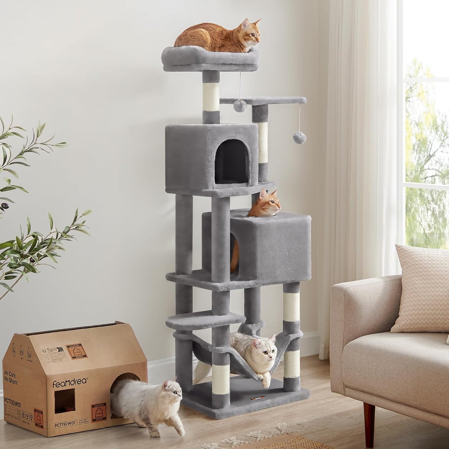 Multiple cats enjoying a large grey cat tree in a living room