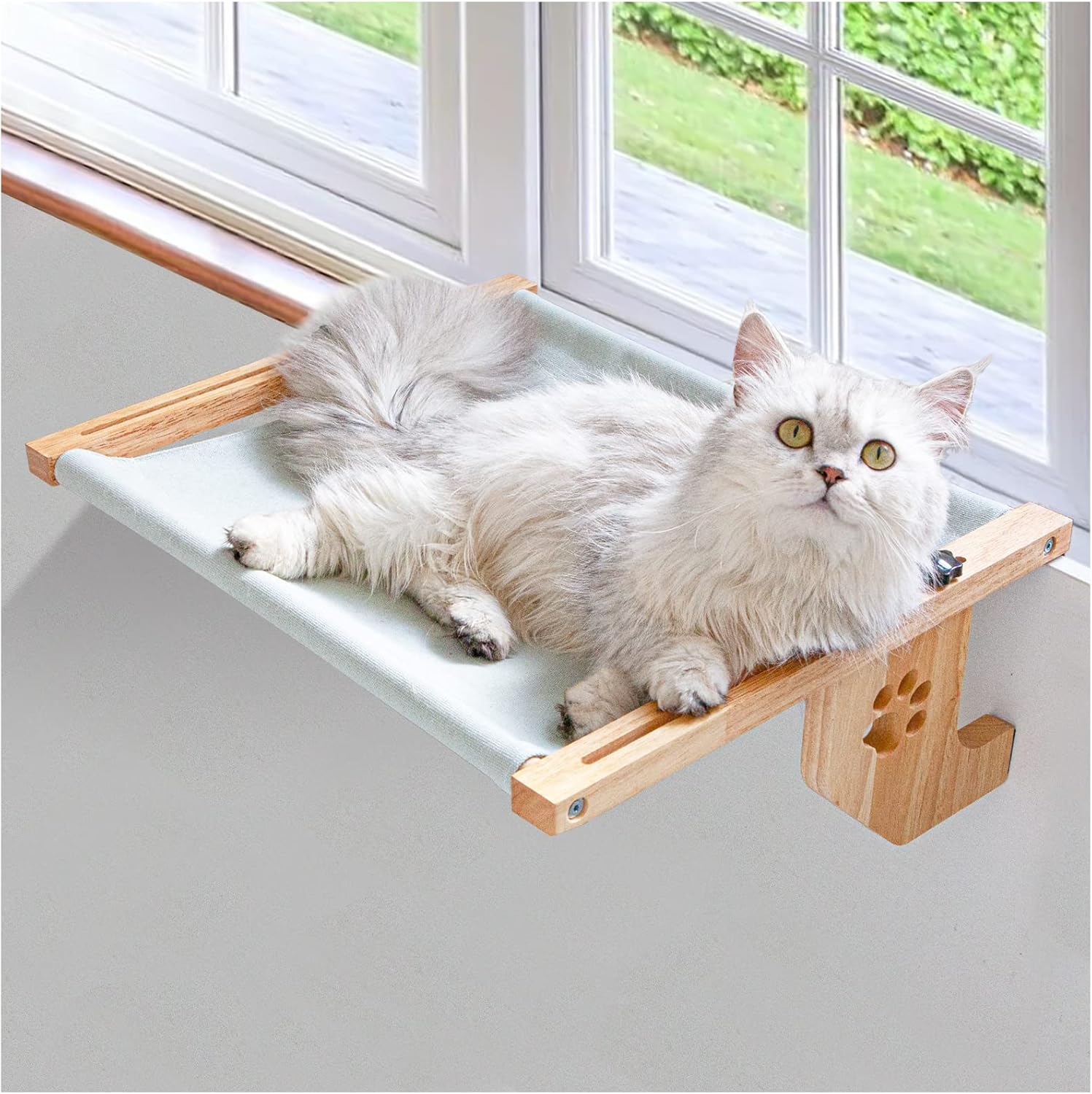 White long-haired cat relaxing on a wooden window-mounted hammock bed