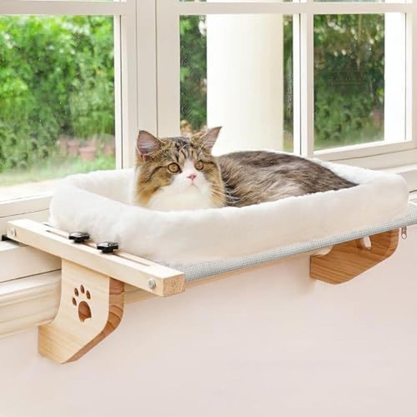 Gray tabby cat resting comfortably on a window-mounted cat hammock cushion bed with wood