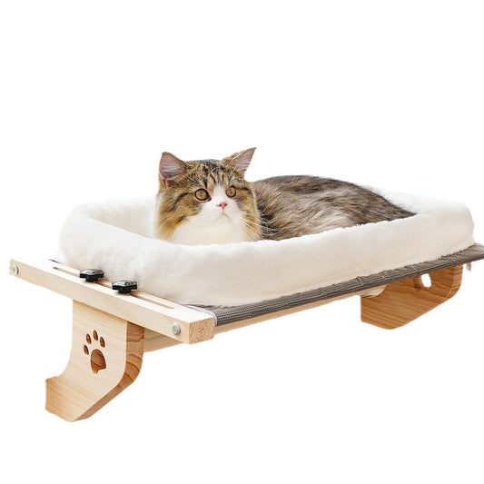 Fluffy cat lying on a wall-mounted cat window perch bed with soft bolster and wooden frame